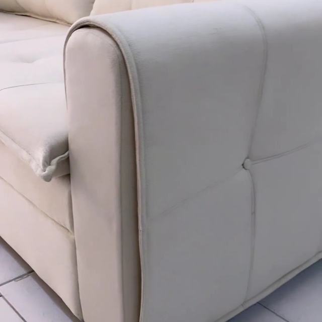 Detalhe do braço e da costura de um sofá bege